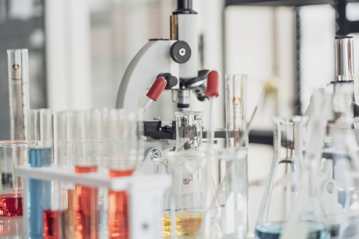 Laboratóriumi üvegeszközök és mérőműszerek egy vizsgálati munkapulton
