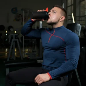 Sportoló edzőteremben shakerből iszik